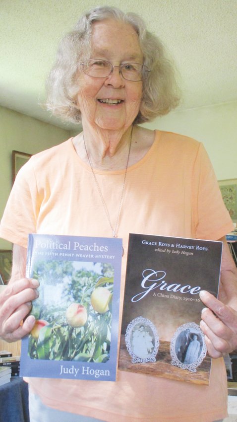 Author Judy Hogan poses with copies of two previous books.