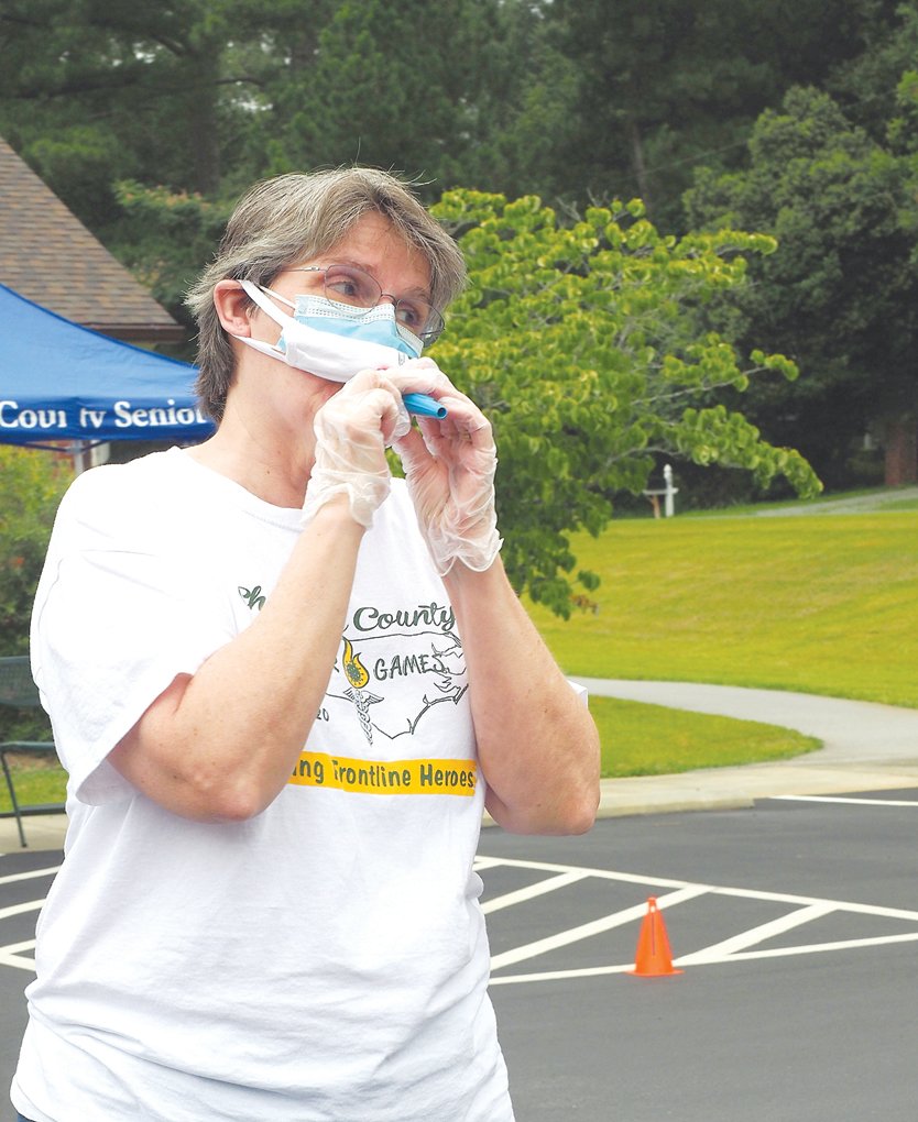 Patricia Cadle fires up the crowd with a kazoo at the Chatham County Senior Games drive-by ceremony on July 30.