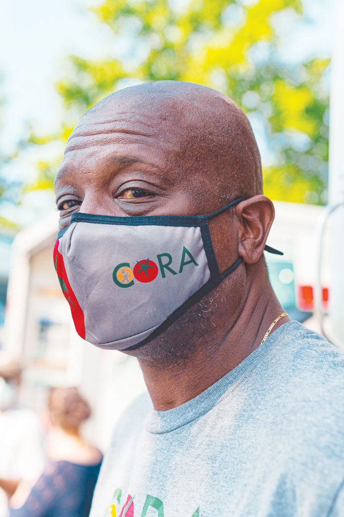 Reggie Blue pauses for a portrait to display his custom CORA face mask, a stylish addition to a wonderful cause.