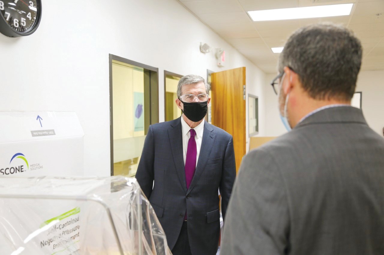 Gov. Roy Cooper speaks with executives from Pittsboro industry Gilero during a visit there earlier this month. Gilero is one of the state's leading producers of PPE (personal protective equipment).
