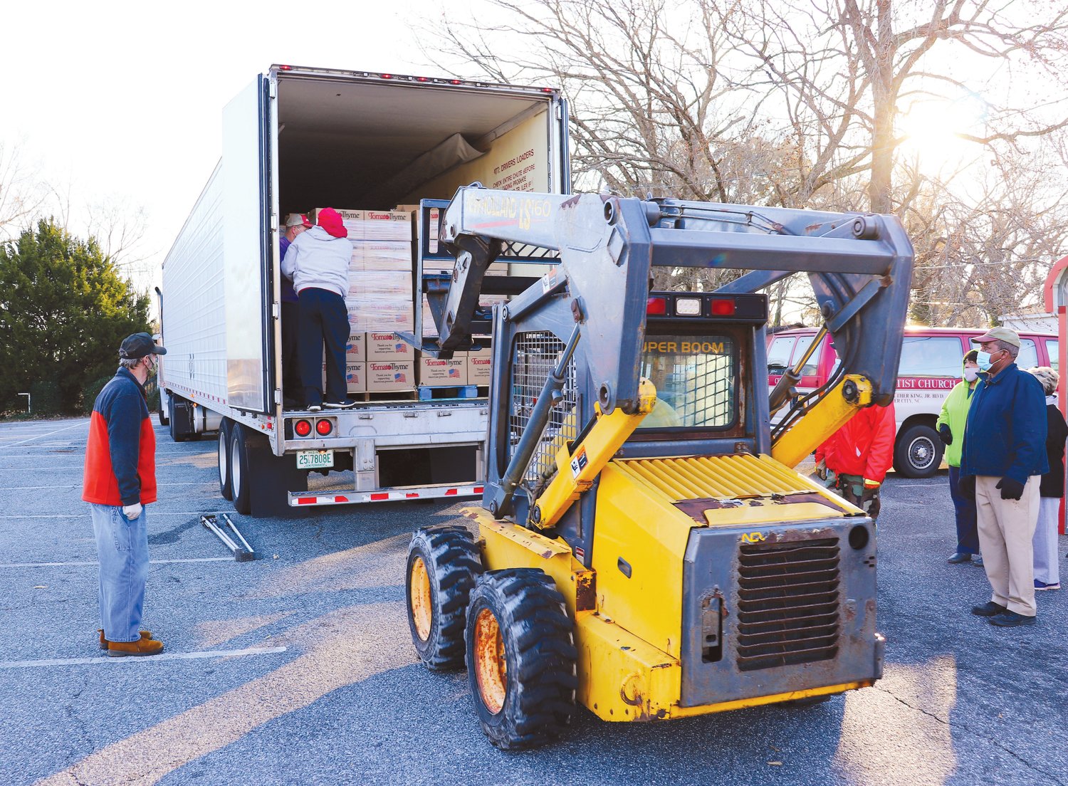Volunteers unload the truck’s 1,248 boxes in the parking lot of First Missionary Baptist Church on Dec. 18. Each box held $50 worth of food.