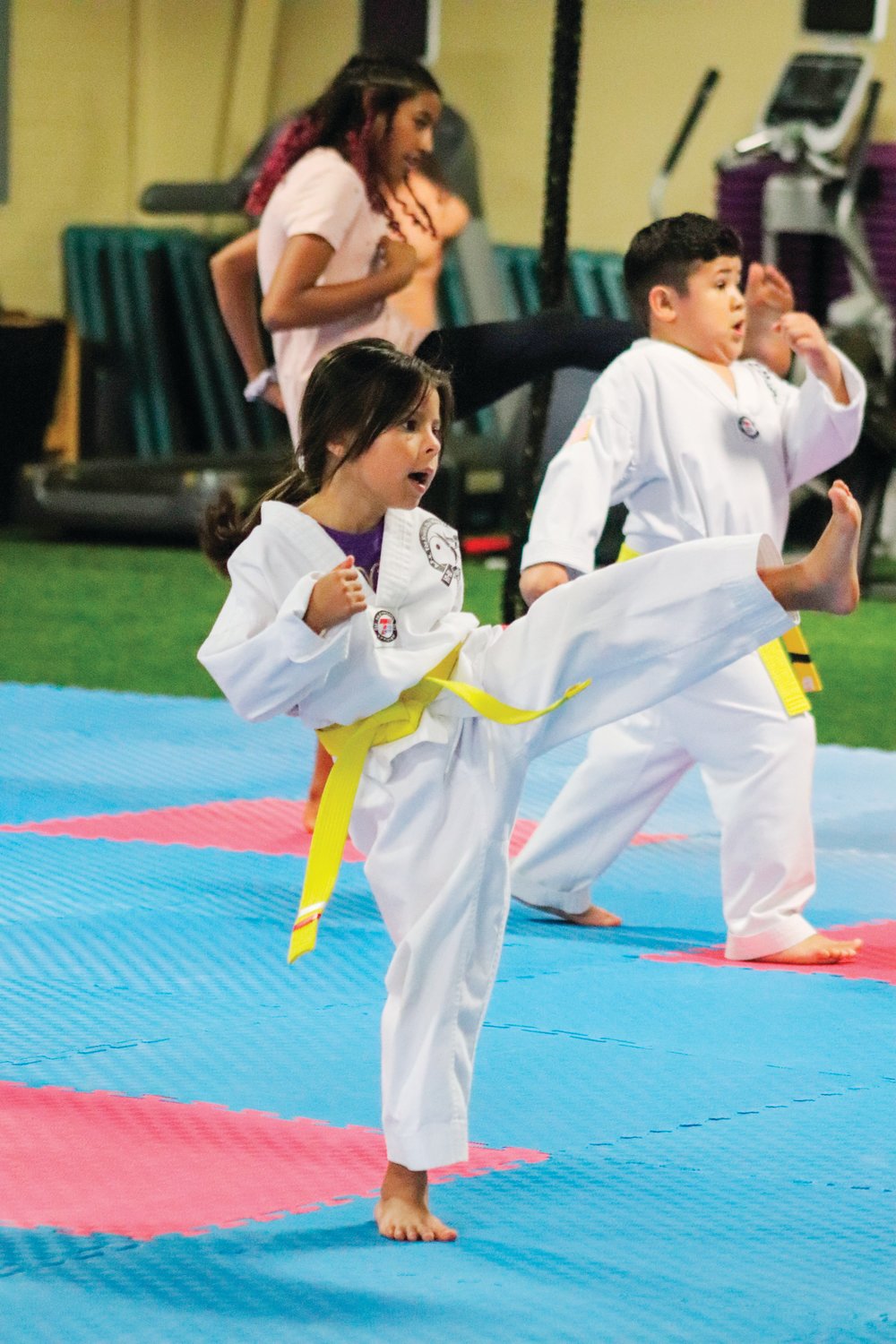 A.F.E. Taekwondo Fitness Academy student Emely Sorto throws a kick during the beginner's class on Monday. Her yellow belt signifies that she's been practicing at the studio for at least 6 months.