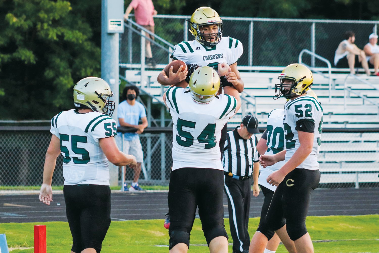 Northwood senior center Robbie Delgado (54) lifts senior running back Jalen Paige (with ball) in celebration after Paige ran for a 13-yard touchdown in the first quarter of the Chargers' 72-0 victory over Jordan-Matthews last Friday.