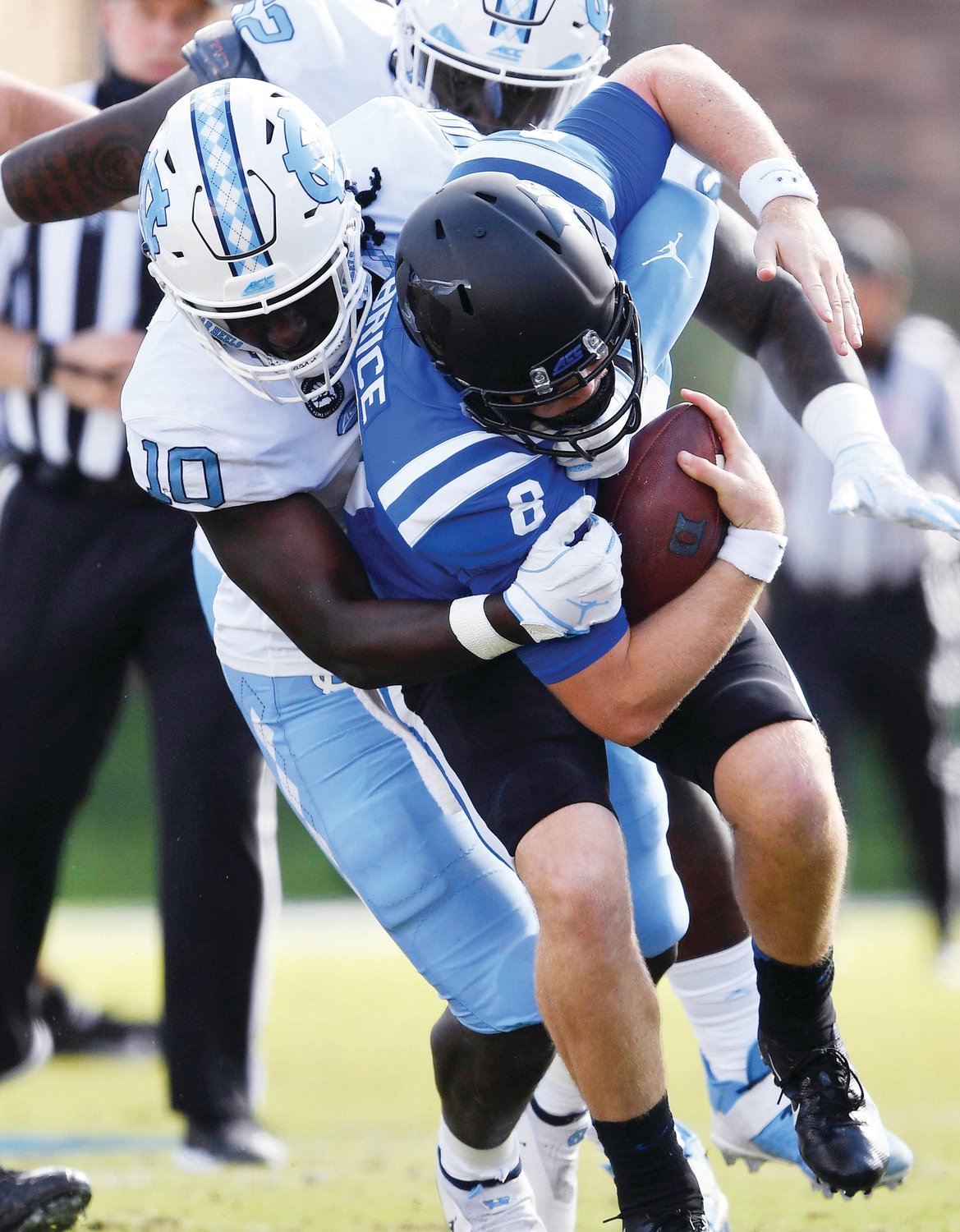 North Carolina linebacker Desmond Evans (10) brings down Duke quarterback Chase Brice (8) in a game against the Blue Devils at Wallace Wade Stadium in Durham on Nov. 7, 2020.