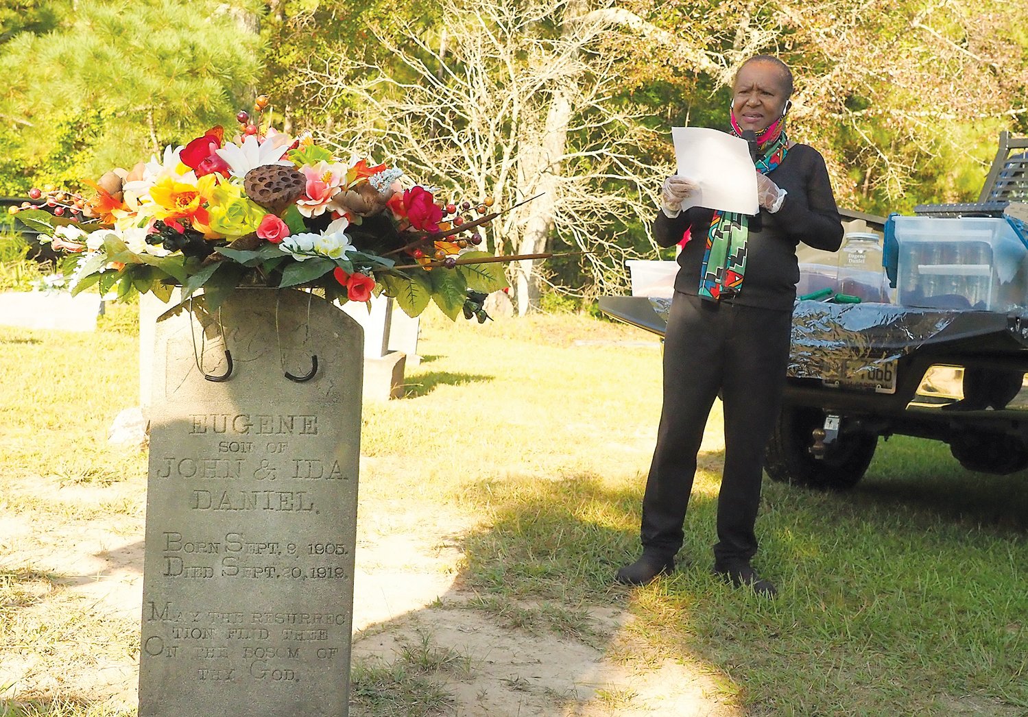 With Eugene Daniel's tombstone nearby, Mary Nettles opened the remembrance service for him at New Hope Baptist Church's cemetery.