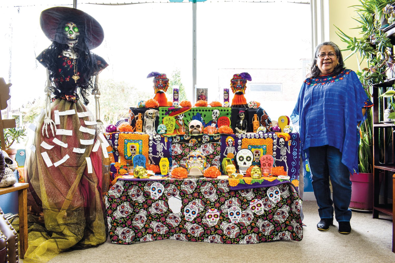 Communities In Schools’ Maria Soto stands next to the Day of the Dead altar she constructed inside the nonprofit’s Siler City office. Day of the Dead, or Día de Muertos in Spanish, is a Mexican and Latin American holiday that honors and remembers deceased loved ones.