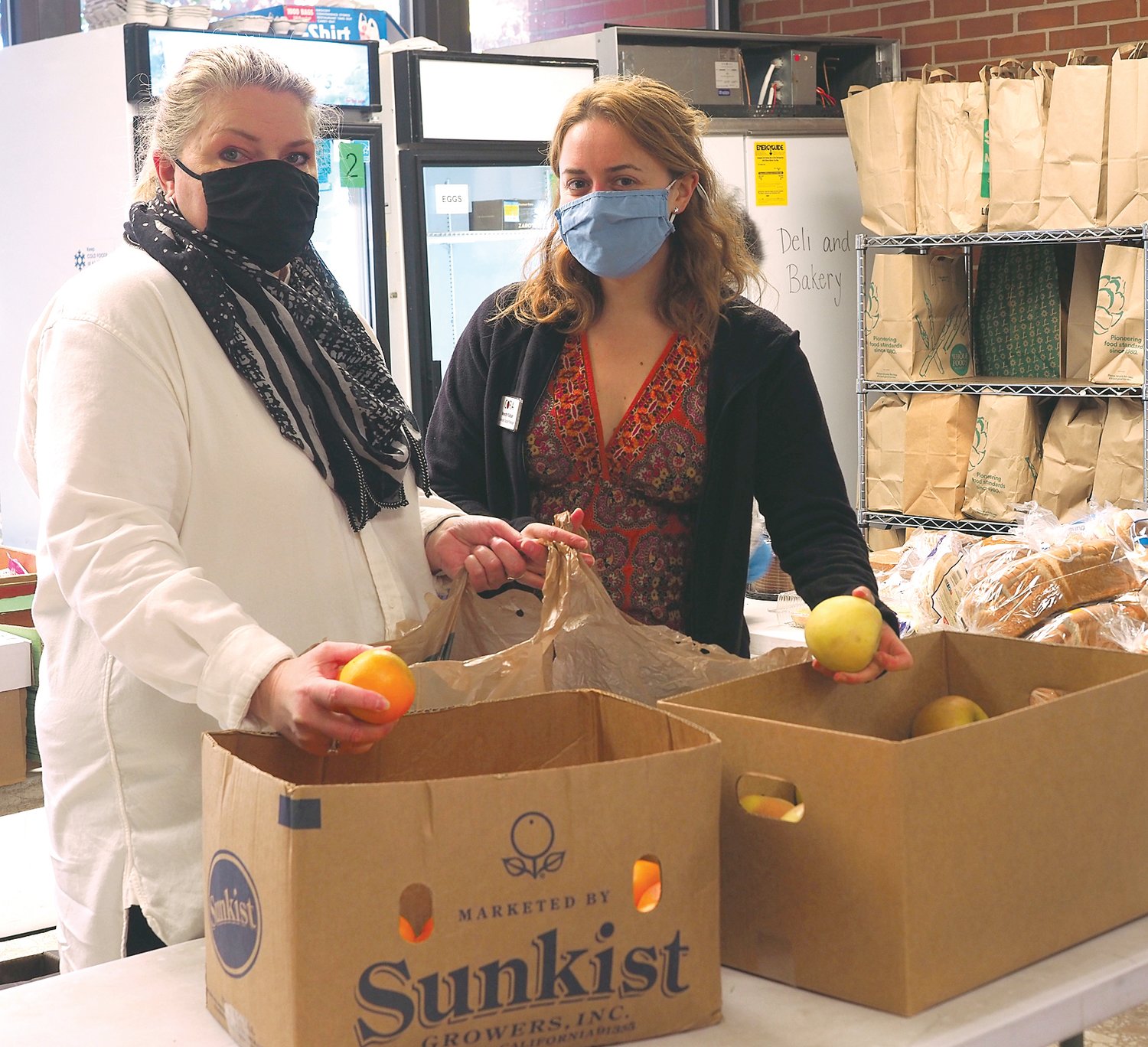 CORA Executive Director Melissa Driver Beard (left) and Community Support Manager Meredith Katibah sort fruits to be distributed to families in need of food.