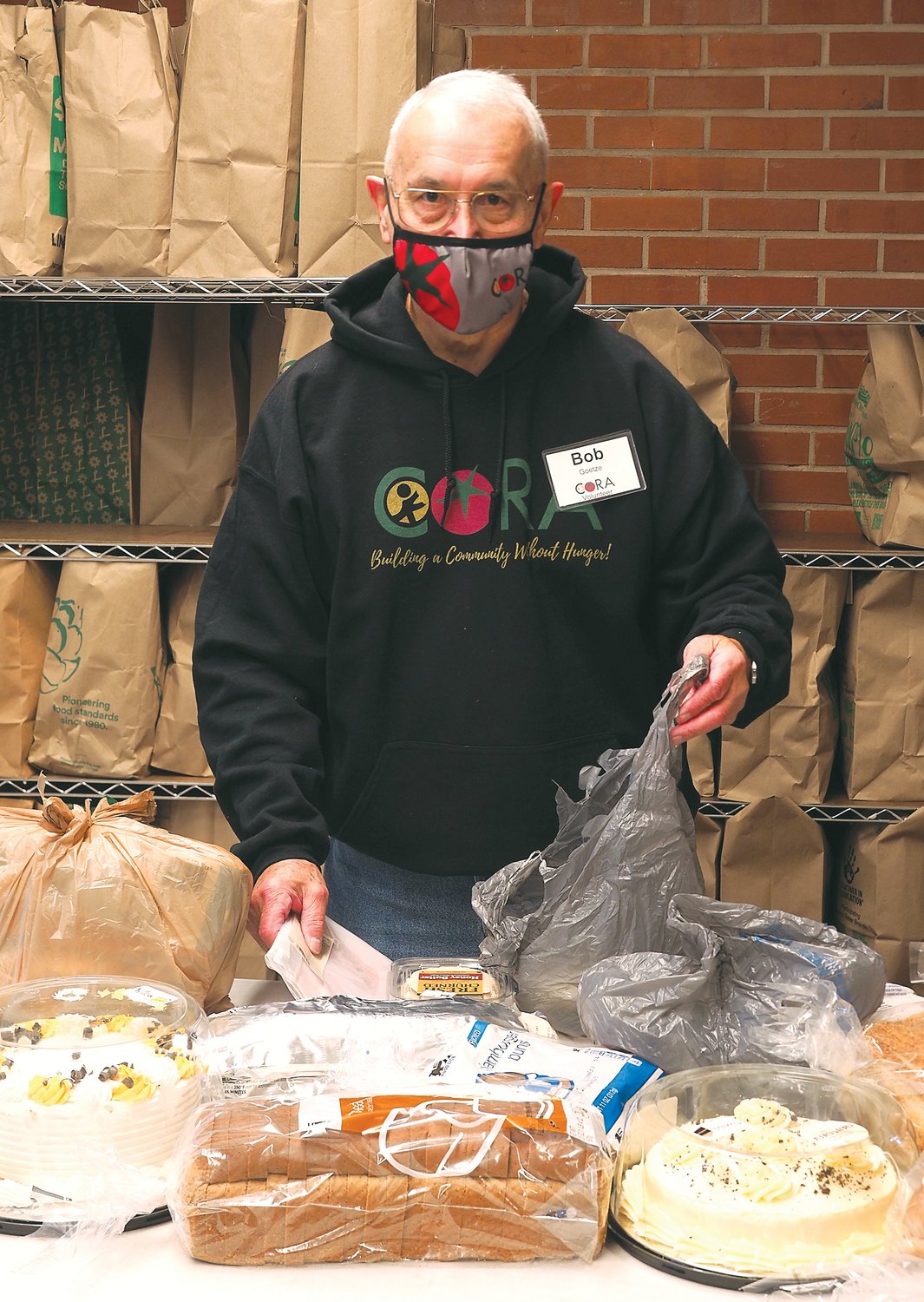 Volunteer Bob Goetze sorts supplemental food bags for CORA recipients. He started volunteering at CORA earlier this year.
