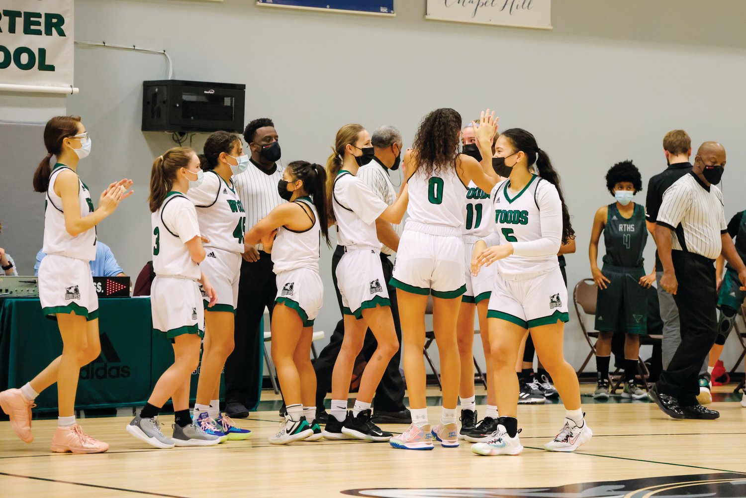 The Woods Charter women's basketball team celebrates after their 53-11 win over Research Triangle in Chapel Hill last Friday. The Wolves head into their holiday break with a perfect 6-0 record.