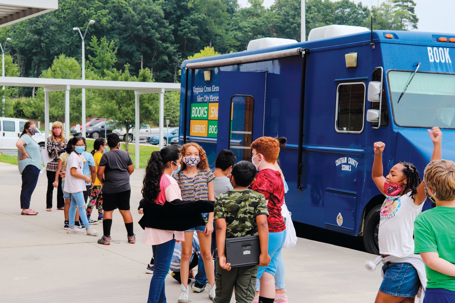 Students line up last July outside of the Bookmobile — a mobile library run by CCS's Siler City and Virginia Cross elementary schools to provide books to low-income students during the summer break from school.