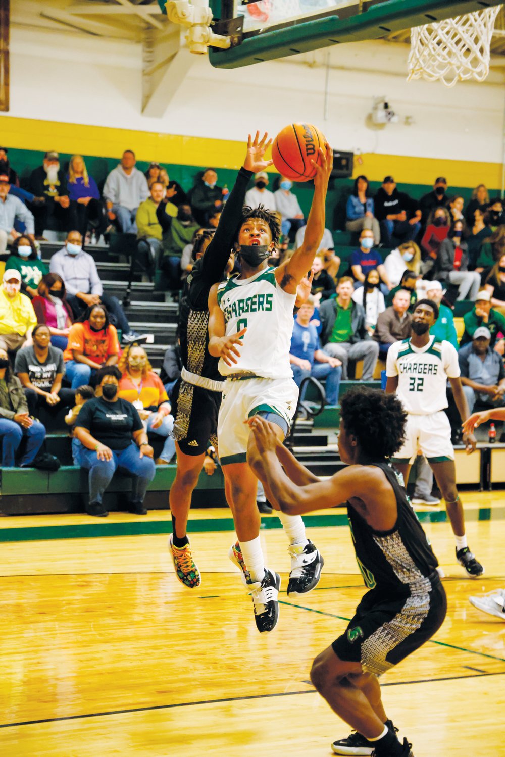 Northwood sophomore Fred Whitaker Jr. (0) avoids a Trojan defender and elevates for a finger roll in the Chargers' 80-40 win over West Brunswick in the 2nd round of the NCHSAA 3A playoffs last Thursday. Whitaker was one of four Chargers in double-figures, scoring 15 points.