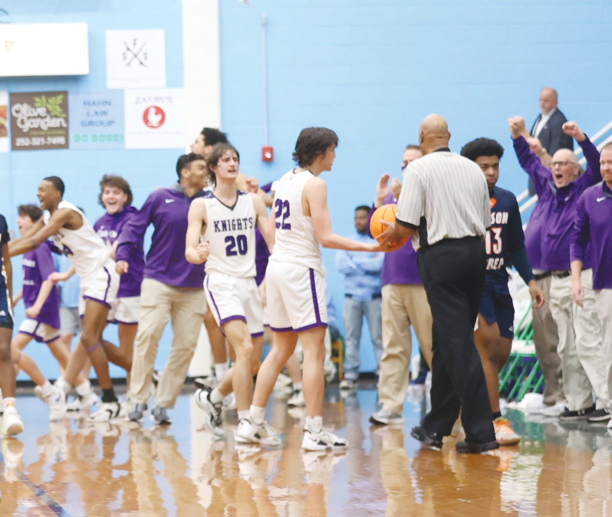 The Chatham Charter men's basketball team, including junior Adam Harvey (20) and Beau Harvey (22), celebrates as the final buzzer sounds at the end of the Knights' 59-42 win over the Wilson Prep Tigers in the NCHSAA 3A East Regional Final last Saturday in Greenville. With the win, Chatham Charter advances to its first state championship game.