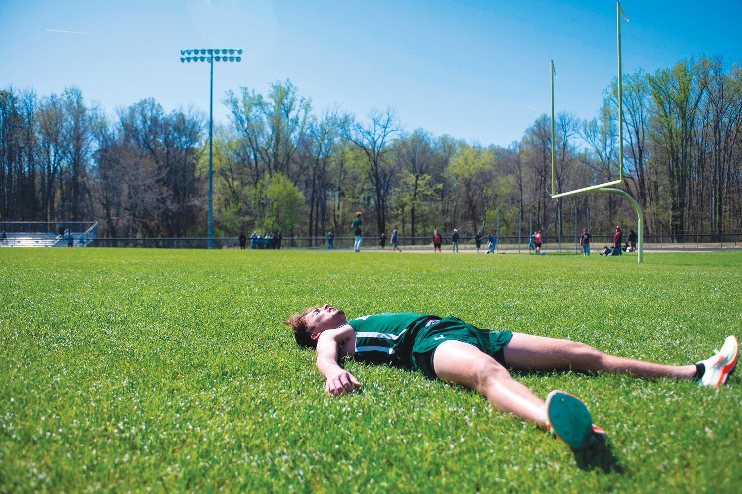 Northwood senior Colin Henry lies in the grass to catch his breath following a relay event on Saturday at the Chatham County Invitational. Henry took first place in the men's 800-meter run (2:15.76) and was part of the first-place men's 4x800-meter relay team that contributed to the Chargers' sweep of the men's relay events.