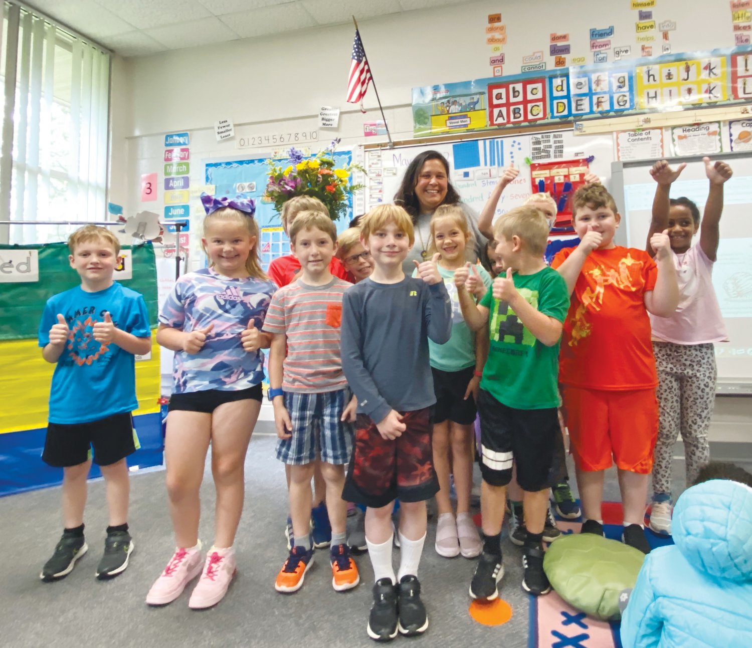 Students at North Chatham Elementary School give Nanette Atkinson (center, rear) thumbs-up for being chosen as the district's 2022-23 Instructional Assistant of the Year.