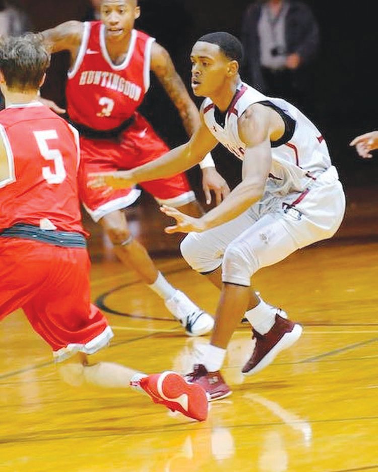 Guilford guard Leonard McNair (in white) defends Huntingdon's Bryant Reid during a blowout win for the Quakers, 90-63, in 2017.
