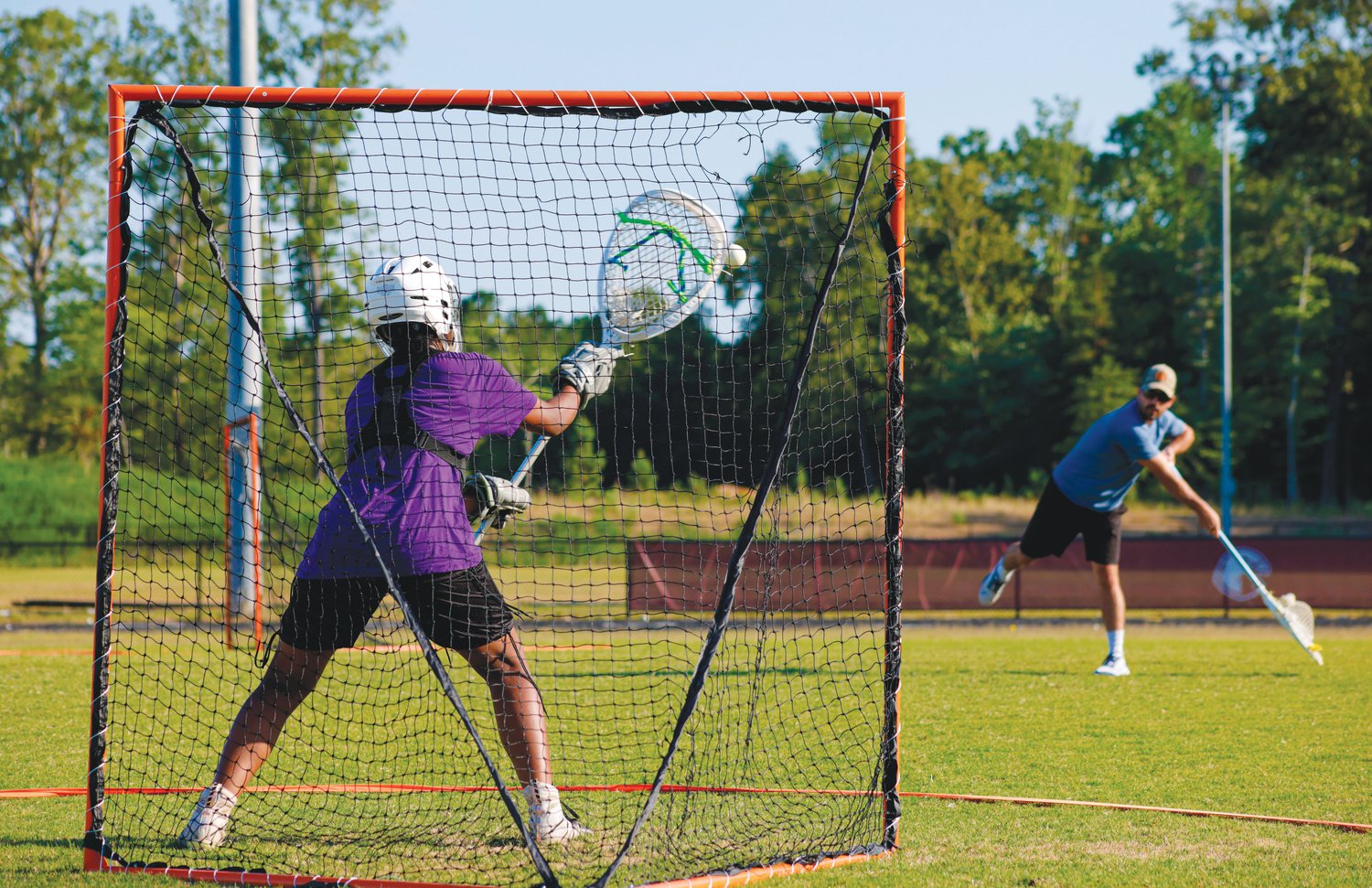 Seaforth camper Jasmine Lawrence (in purple) stands in goal and attempts to save a shot during the Hawks' youth lacrosse camp last Thursday.