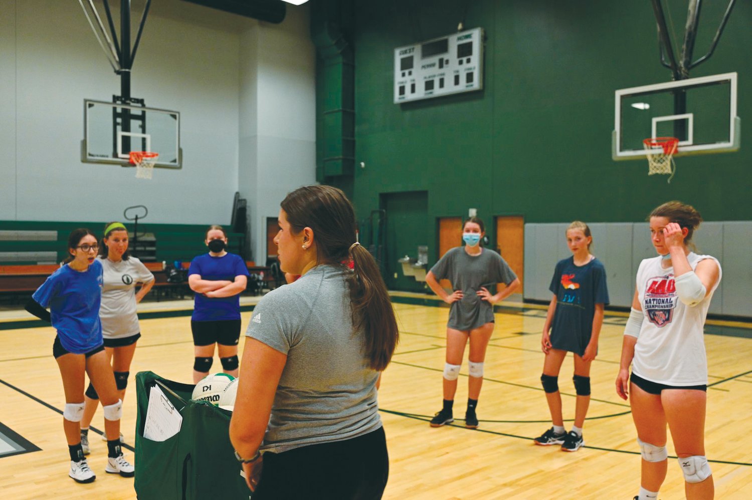 Wood Charter head volleyball coach Amanda Gough (center) speaks to her team during her first open gym session as the Wolves' head coach.