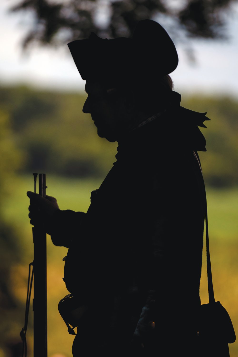 A man dressed in colonial-era attire stands in waiting for a battle reenactment. Last Saturday saw a retelling of the 1781 battle that took place during the American Revolution at the Alston House in Sanford.