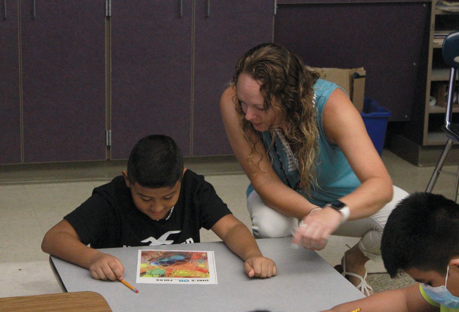 Fifth grade teacher Ms. Baker helps one of her students with a worksheet on the first day of school on Monday at Virginia Cross Elementarry in Pittsboro.