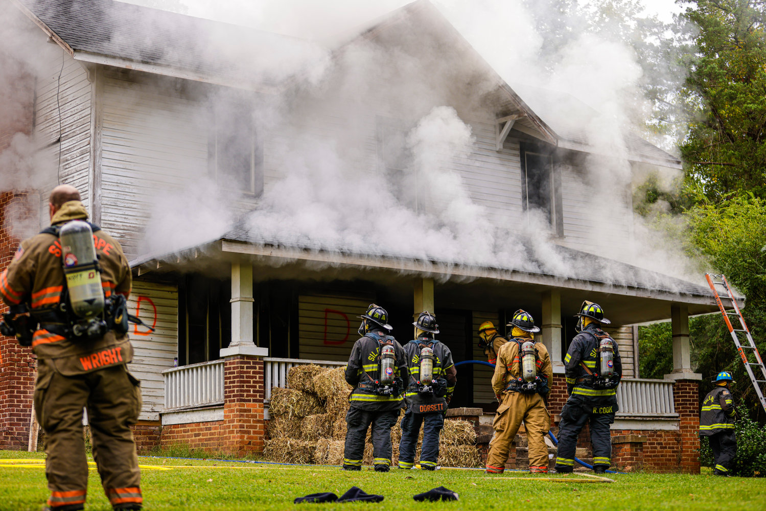 Smoke billows from the home on Alston Road, as firefighters from different departments across the county wait to enter the Siler City house used for the live burn.