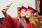 GRADUATION: A moment in time..Nevaeh Bales, left, holds a smartphone out to get a selfie with Brittany Brooks in the last minute preparations for Chatham Central’s graduation at the civic center Friday.