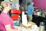 Kendra Oldham waits to pay as Basil Hart prepares her coffee selection Thursday at the Blue Dot in downtown Pittsboro.
